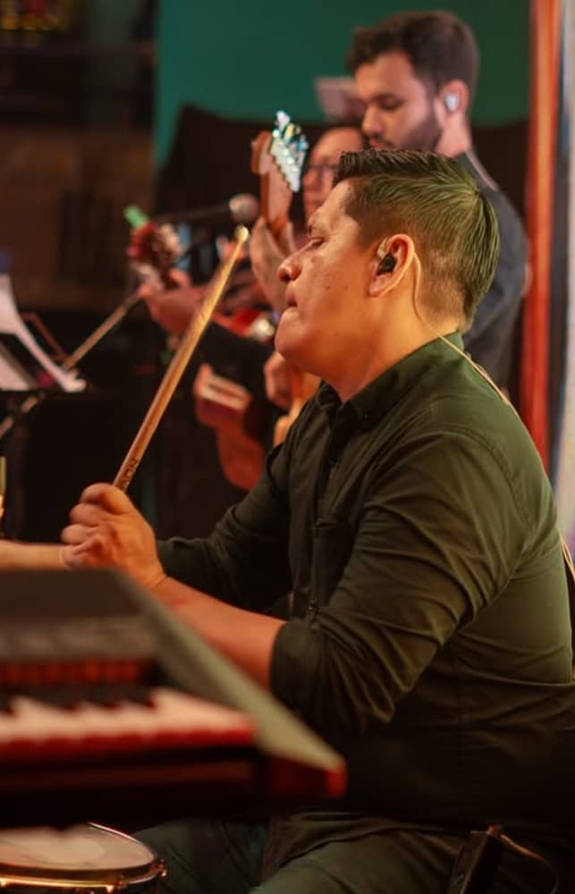 Percusionista y banda tocando en vivo durante una noche en Plaza Juárez